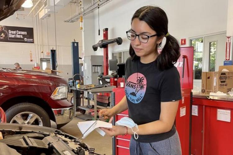 Nataly Ramirez working on a car.