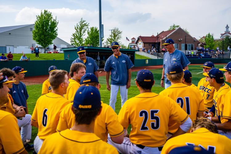 Baseball team listening to the coaches prior to a game.