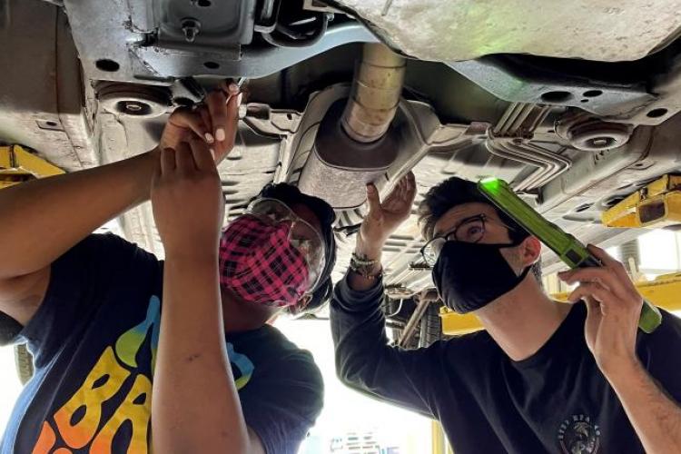 Indonesia Carpenter and Alex Estrada working on a car.