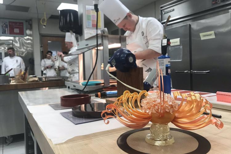 Chef preparing pulled sugar dessert in the competition.