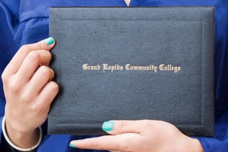 A student holds up a Grand Rapids Community College degree.