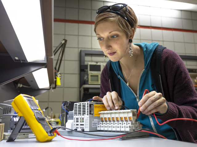 Woman working on mechatronics project at GRCC.