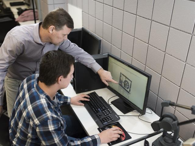 Student and professor working together on architectural technology in the lab.